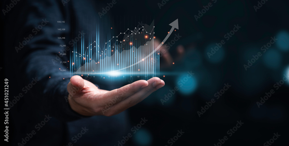 Wall mural businessman or trader showing glowing virtual technical investment graph chart for analysis stock ma