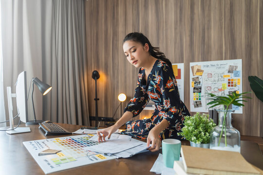 portrait of asian female woman entrepreneur smile with confident and cheerul looking at camera with background of material sample chart home office background - Powered by Adobe