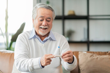 Old senior asian male hand nasal swab testing rapid tests by himself for detection of the SARS co-2 virus at home isolate quarantine concept