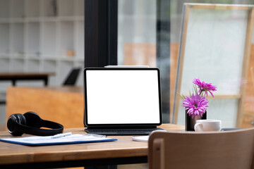 Mock up digital tablet with blank white screen on workplace at office. Online Education Concept