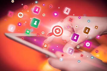 Close-up of a hand using tablet with social media icons