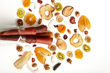 Fototapeta na wymiar Above view of delicious fruit and berries lozenge and dried orange, apricot, raisins, walnuts, dried apples and kiwi on white background. Concept of healthy assorted dried fruit for snacks.
