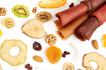 Close up of fruit lozenge different colors and almonds, orange, dried apricot, raisins, walnuts, dried apples and kiwi on white background. Concept of mixed dried fruits on table.