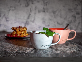 Tea in two ceramic mugs and homemade waffles