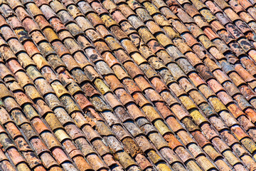 Vielle toiture de tuiles romaines traditionnelles en terre cuite sur une maison ancienne du sud de...