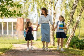 Obraz premium Parent and pupils going to school