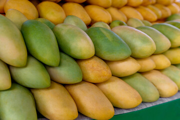 Mango festival. Stand with fresh yellow mango fruits in the street market. Selective focus.