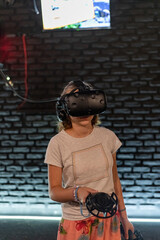 The girl in the virtual reality room plays computer games.