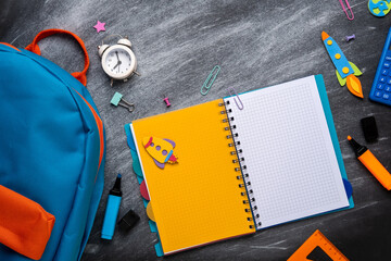 School backpack with Сolorful school supplies on the background of black chalkboard. Back to school, education concept.