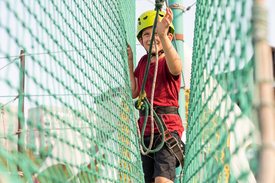 A sports boy on the cable car between the grids in the extreme park overcomes obstacles.