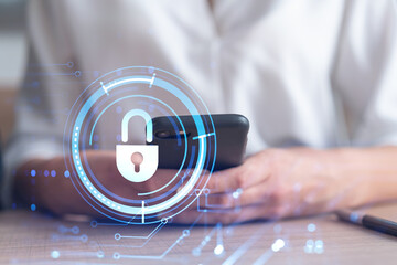 A woman programmer is browsing the Internet in smart phone to protect a cyber security from hacker attacks and save clients confidential data. Padlock Hologram icons over the typing hands. Formal wear