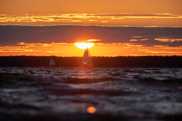 Sailing boat at sunset of the big sun