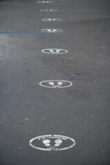 Social distancing circles on sidewalk in France that say 'wait here' 