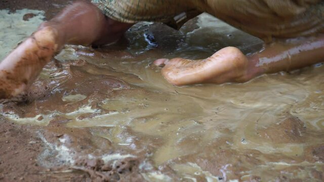 Underprivileged children happily playing in muddy water