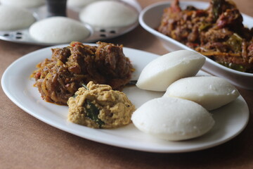 Steamed rice cake is popularly known as Idly in India is one of the healthiest breakfast item of Indian Cuisine. Served with Kerala style spicy mutton roast and chutney.