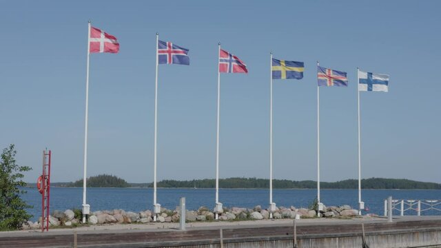Six nordic country flags waving in a wind. Denmark, Iceland, Norway, Sweden, &Aring;land and Finland National Flag. Shot in Finland in the nortwest archipelago area in summer.