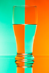 refraction of light by a glass on a green and orage squared background. Abstract glass art.