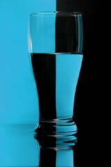 refraction of light by a glass on a blue and black squared background. Abstract glass art.