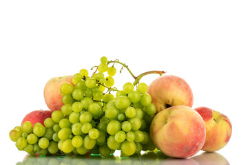 One ripe bunch of seedless grapes and several peaches , close-up, isolated on white.
