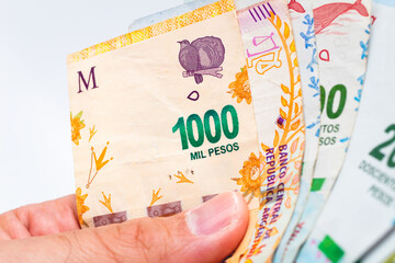 Money, Argentine Peso - ARS. A man holding a argentine money banknotes with white background.