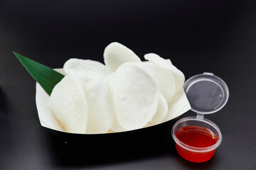 Junk food or fastfood concept. Rice chips on a black-white paper plate with sweet and sour or spicy...