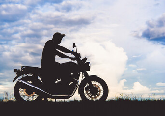 Fototapeta na wymiar black shadow men on classic motorbike beautiful sunset sky background