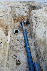 a trench in the ground with new plastic pipes, work activities to replace old iron pipes with new...