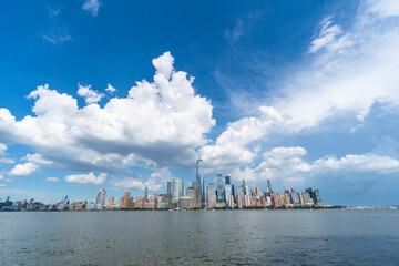 Fototapeta premium Summer clouds float above the Lower Manhattan skyscraper on June 9 2021 in New York City NY USA.