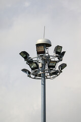 A spotlight located in the middle of the park against the backdrop of a white cloud-covered sky.