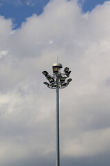 A spotlight located in the middle of the park against the backdrop of a white cloud-covered sky.