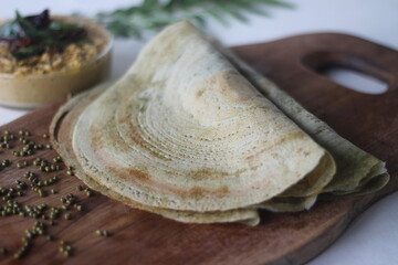 Fototapeta na wymiar Protein rich moong bean crepe, locally known as pesarattu. It looks like dosa but not made with fermented batter