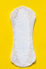 Feminine hygiene panty liner for menstruation. Menstrual cycle, pad. Yellow background.  