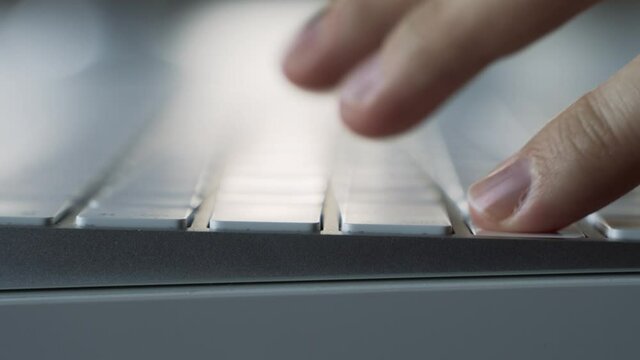 Male hands typing on a white computer keyboard. Macro. Slide zoom in.