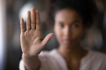 Crop close up focus of African American woman show palm hand against racial gender discrimination. Determined mixed race female make sign gesture protest against domestic violence or abortion. - obrazy, fototapety, plakaty