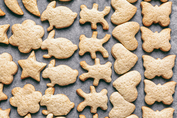 baked homemade cookies in the form of various animals on parchment craft paper, Christmas or New Year's treats, top view