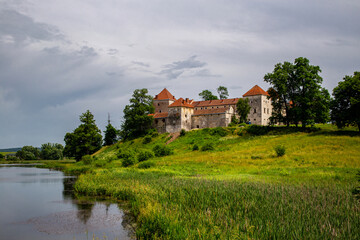 Beautiful panorama of Svirzh castle by the river on a summer day, near Lviv.