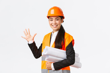 Smiling professional asian female engineer, architect giving five month for construction, carry...