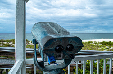 Binoculars view the storm. Port Boca Grande Lighthouse and Museum stand strong on Gasparilla Island as a tropical storm with black clouds loom of the coast in the Gulf of Mexico