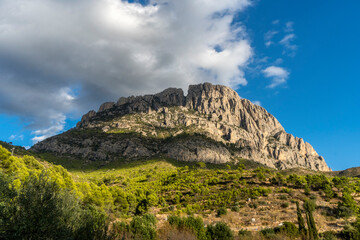 Fototapeta na wymiar imposing mountain Puig Campana with a blue cloudy sky. Landscape located in Finestrat, located in the Valencian Community, Alicante, Spain