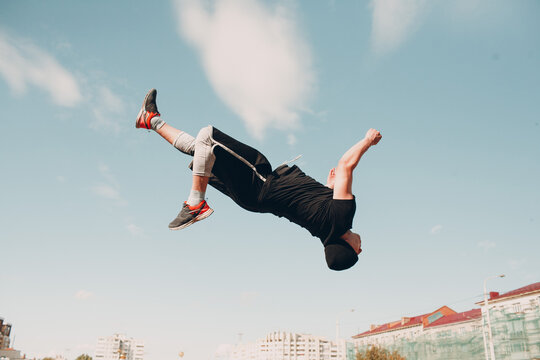 Young sporty guy doing parkour at the city street