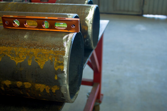 billets of pipes on a steel table with a level