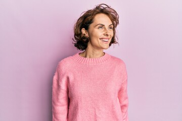 Young brunette woman wearing casual winter sweater looking to side, relax profile pose with natural face and confident smile.