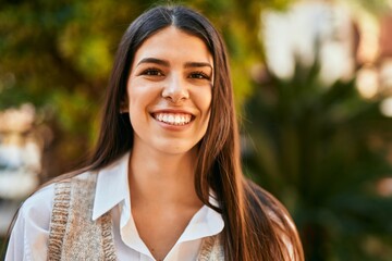 Young hispanic woman smiling happy standing at the city.