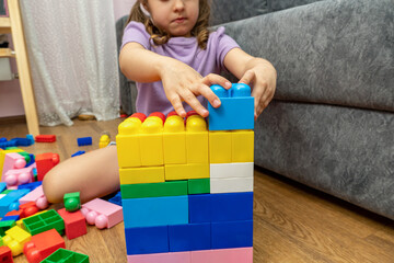 small kid girl playing with educational toy blocks constructor