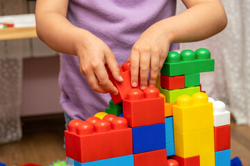 kid, child hands, while playing with educational toy blocks constructor