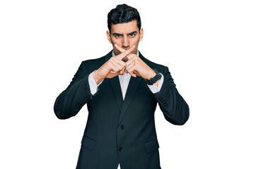 Handsome hispanic man wearing business clothes rejection expression crossing fingers doing negative sign