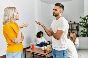 Obraz premium Two young friends standing and speaking at home.