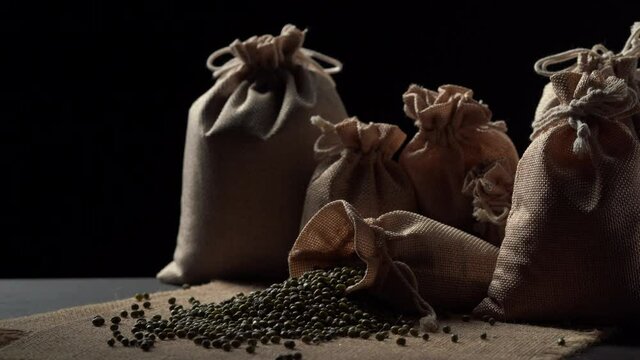 Mung beans on burlap against dark background