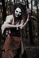 Halloween theme: terrible crazy voodoo witch killing by staff. Portrait of evil sorceress in dark...