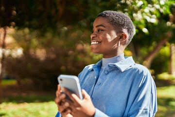 Young african american woman smiling happy using smartphone at the city